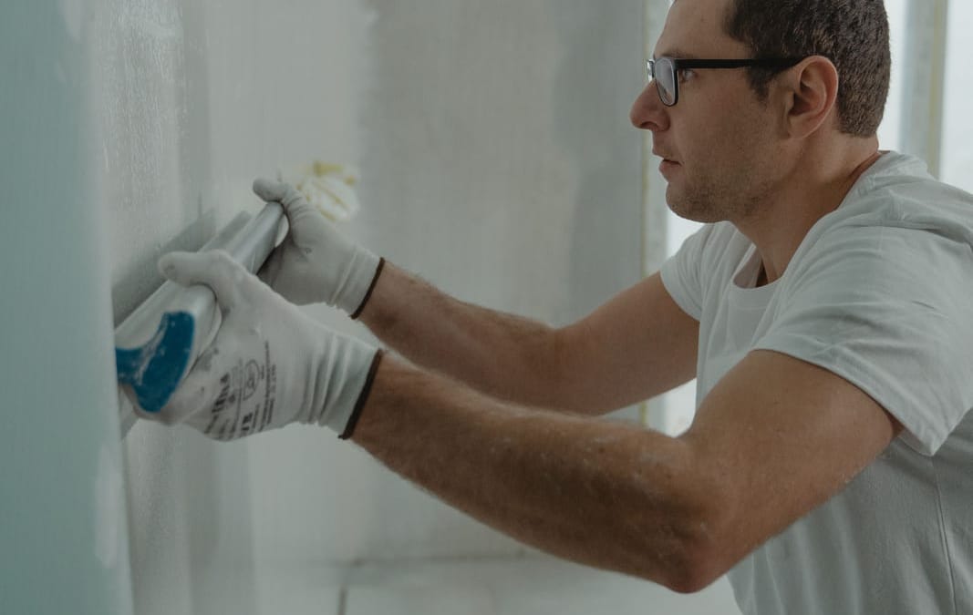 Handwerker verspachtelt Plattenfugen an einer Trockenbauwand