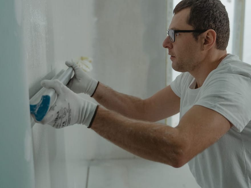 Handwerker verspachtelt Plattenfugen an einer Trockenbauwand