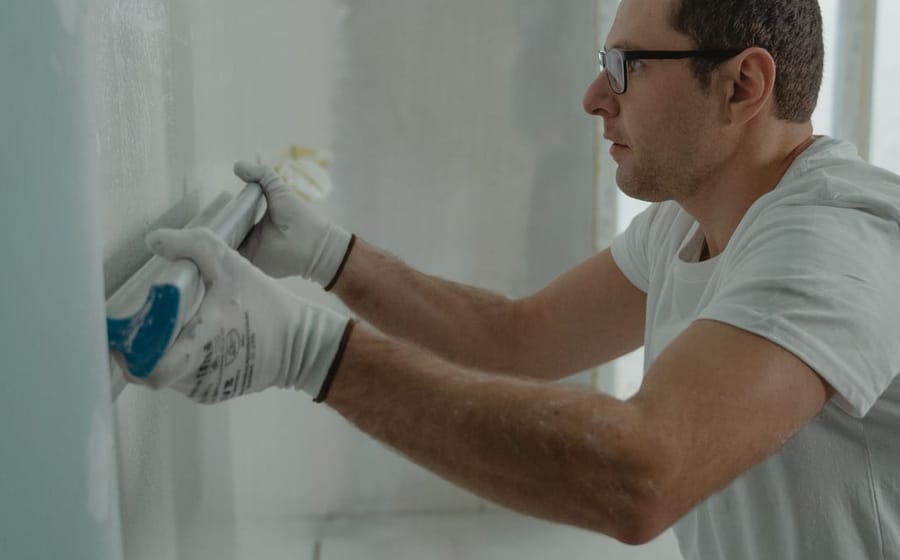 Handwerker verspachtelt Plattenfugen an einer Trockenbauwand