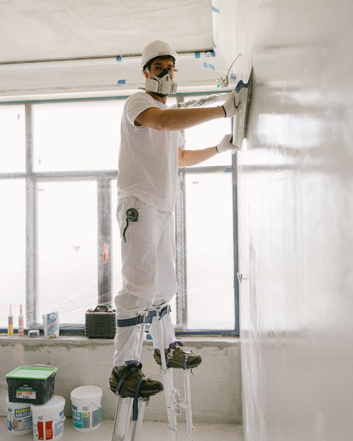 Handwerker glättet eine Wandfläche im hellen Tageslicht